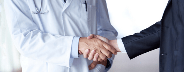 Doctor shaking hands with a man in a suit jacket